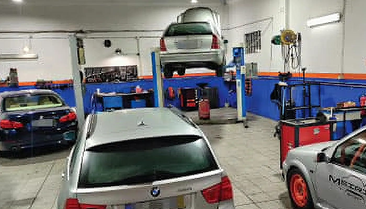 Interior da oficina com carros em reparação